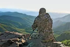 Hunter with binoculars overlooking BC mountains – BC Hunting Synopsis 2025
