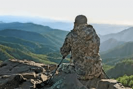 Hunter with binoculars overlooking BC mountains – BC Hunting Synopsis 2025